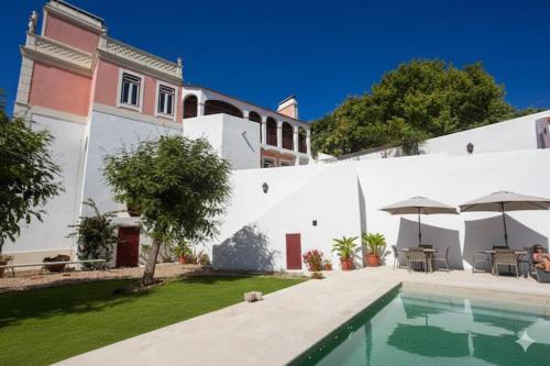 a house with a swimming pool next to a white building at SOLO ! Charme Boutique in Avis