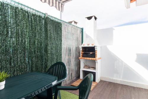 a green wall with a table and chairs on a balcony at Caparica Balance Apartment, 2 bedroom in Costa da Caparica