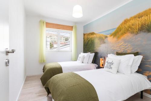 a bedroom with two beds and a painting on the wall at Caparica Balance Apartment, 2 bedroom in Costa da Caparica