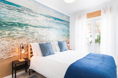 a bedroom with a large painting of the ocean at Caparica Balance Apartment, 2 bedroom in Costa da Caparica