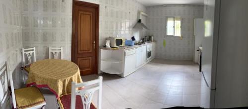 a kitchen with a table and a table and chairs at Casa familiar La Cabra in Talavera de la Reina