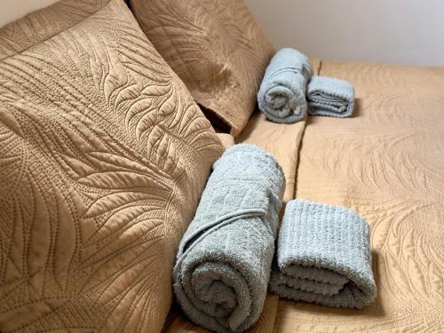 a bed with towels and pillows on it at Apartamento Central in Passos