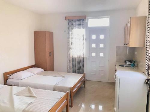 a small room with two beds and a refrigerator at Apartments In Amor in Ulcinj