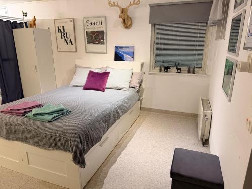 a bedroom with a bed with purple pillows at Northern Lights Apartment for Independent Stay in Jukkasjärvi