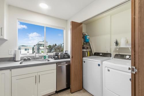 a kitchen with white appliances and a window at Cozy Hilltop Seattle Stay with Yard & Parking in Seattle