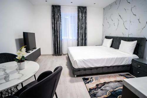 a bedroom with a bed and a table and chairs at LaRin Residence in Bucharest