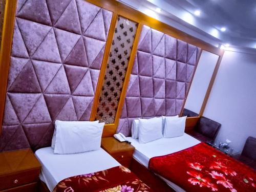 two beds in a small room with a head board at Sunrise BnB in Karachi