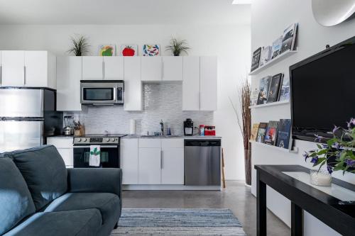 a living room with a couch and a kitchen at Modern, Dog Friendly Apartment with a Private Patio in Dallas