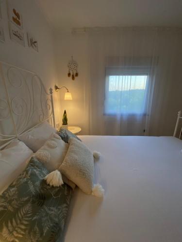 a white bed with a stuffed animal on it at Vikendica Fruška lipa in Čortanovci