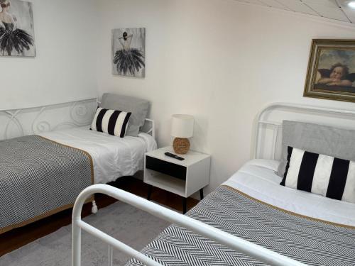 a bedroom with two beds and a lamp on a table at Apartamento Deluxe II RB in Ribeira Brava