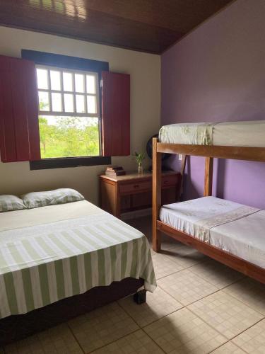 a bedroom with two bunk beds and a window at Casa Ypê in Pirenópolis