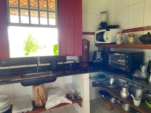 a kitchen with a sink and a window at Casa Ypê in Pirenópolis