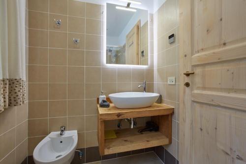 a bathroom with a sink and a mirror at Dolomiti Comfortspace Free Parking in San Niccolò Comèlico