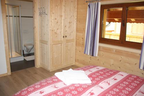 モルジャンにあるEdelweiss B31の木製の部屋にベッド1台が備わるベッドルーム1室があります。