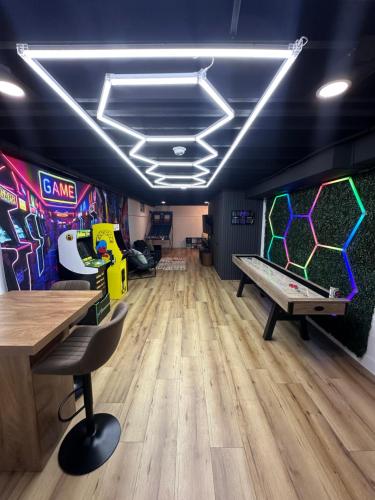 a room with a ping pong table and a video game at Arcade Game Room! Luxury New 3BR CLE Clinic UnivCircle Little Italy in Cleveland