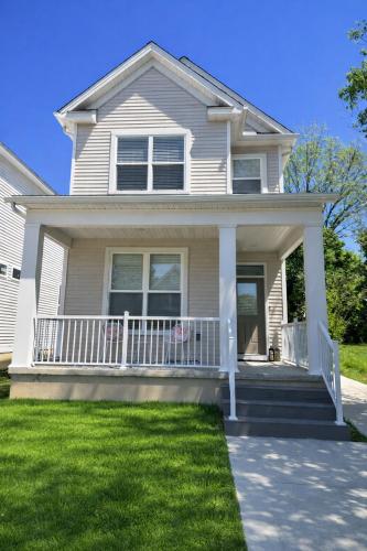 a white house with a porch and grass at Arcade Game Room! Luxury New 3BR CLE Clinic UnivCircle Little Italy in Cleveland