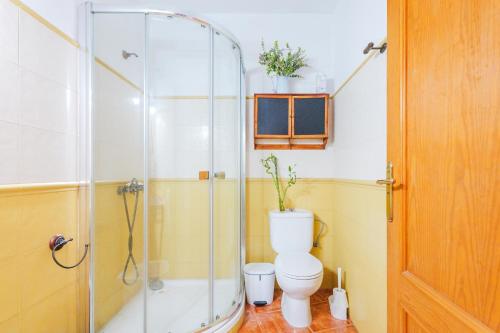 a bathroom with a toilet and a glass shower at Casa Petra - Traditional Canary House in Güimar