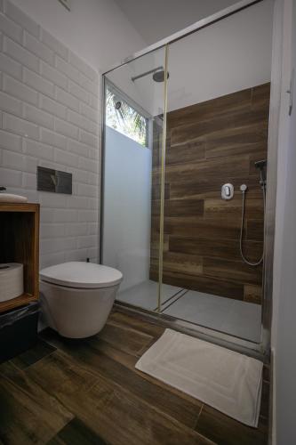 a bathroom with a toilet and a glass shower at Somewhere In Bocas in Bocas Town