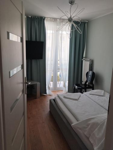 a bedroom with a bed and a large window at Na Sadowej in Grodzisk Mazowiecki