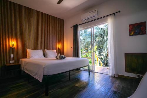 a bedroom with a bed and a large window at Somewhere In Bocas in Bocas Town
