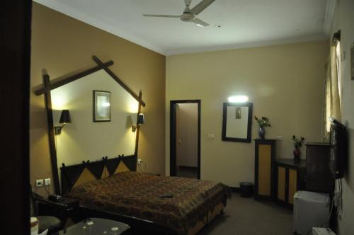 a bedroom with a bed and a mirror at Hotel Pratiksha in Morādābād