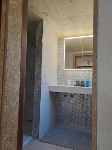 a bathroom with a sink and a shower with a mirror at Casa Dani Danis in Danis