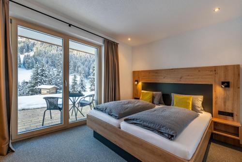 a bedroom with a large bed and a large window at Ferienhaus Leo in See