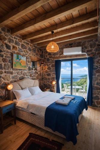 a bedroom with a bed and a large window at FİNTOZ BUTİKA New in Karaburun