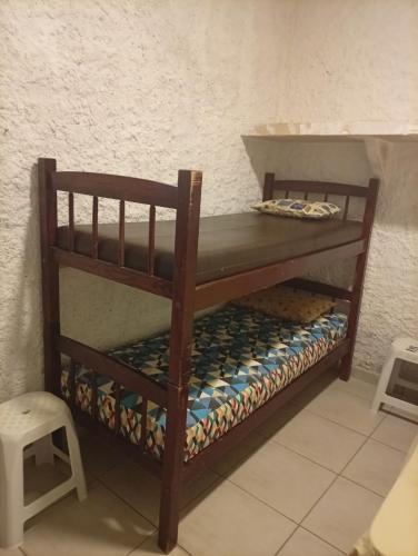 a wooden bunk bed in a room at Sol & mar Hospedagem - Boqueirão Sul Via Balsa Cananéia in Ilha Comprida