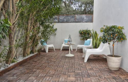 a patio with chairs and a table and trees at Il Vicolo B&B in Milazzo