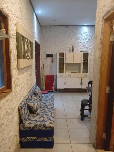 a living room with a couch and a kitchen at Sol & mar Hospedagem - Boqueirão Sul Via Balsa Cananéia in Ilha Comprida