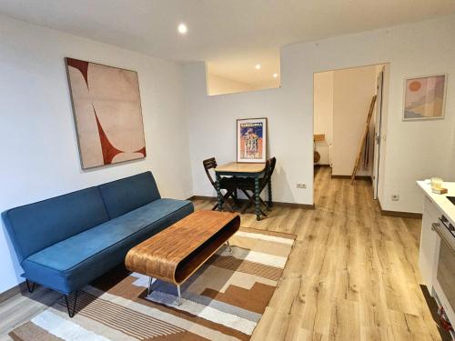 a living room with a blue couch and a table at Poolside Apartment Barcelona Sant Cugat in Sant Cugat del Vallès