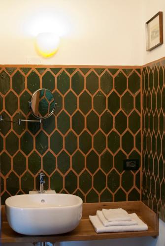 a bathroom with a sink and a green tiled wall at La Lepre Bianca in Cento