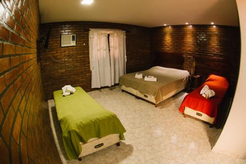 a small bedroom with two beds and a window at Posada Madre America in San Ignacio