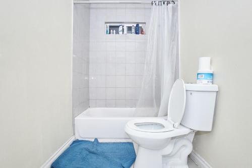 a bathroom with a white toilet and a bath tub at Blue Urban Stay LA in Los Angeles
