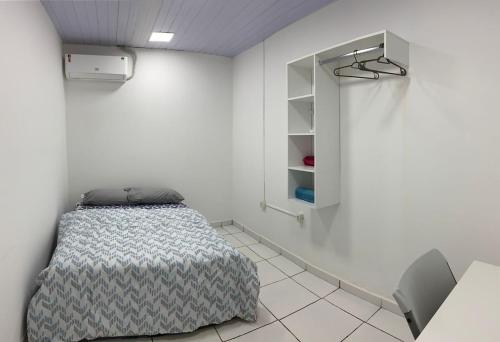 a bedroom with a bed in a white room at Apartamento com 3 quartos in Boa Vista