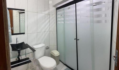 a bathroom with a toilet and a glass shower at Apartamento com 3 quartos in Boa Vista