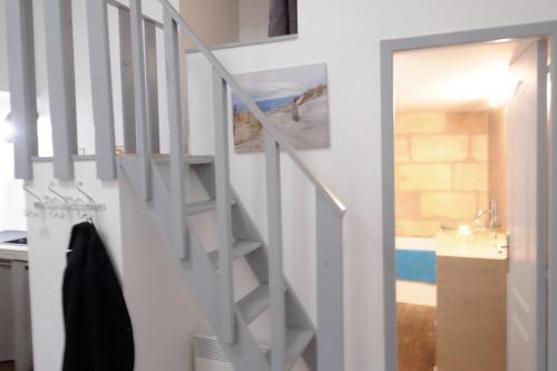- un escalier blanc dans une cuisine avec une porte dans l'établissement Appartement Bordeaux Victoire, à Bordeaux