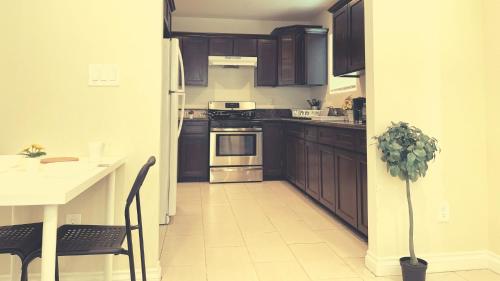 a kitchen with brown cabinets and a white floor at Blue Urban Stay LA in Los Angeles