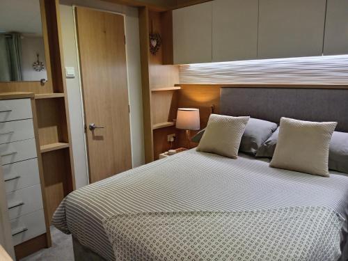 a bedroom with a large bed and a cabinet at Newquay Bay Resort - Poppy's Lodge Retreat in Newquay