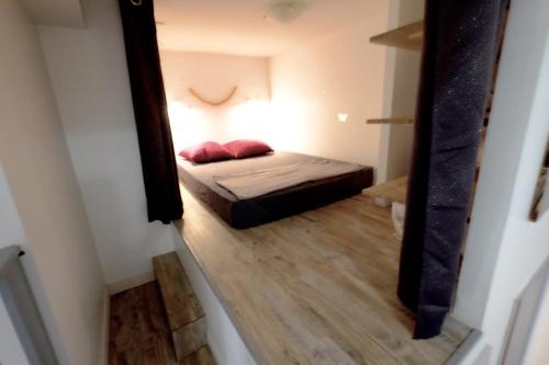 une petite chambre avec un lit et un miroir dans l'établissement Appartement Bordeaux Victoire, à Bordeaux