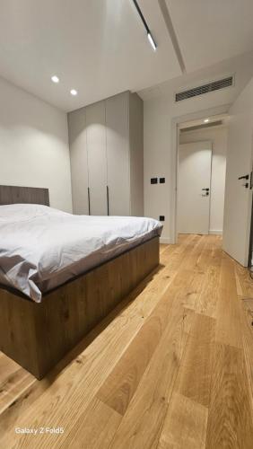 a bedroom with a bed and a wooden floor at Zemun Golax Apartments in Belgrade
