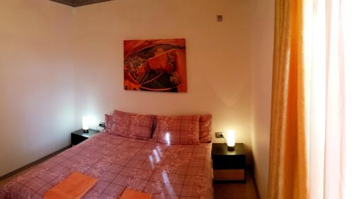 サニービーチにあるKamelia Garden Mikosta Apartmentのベッドルーム1室(ベッド1台付)が備わります。壁には絵画が飾られています。