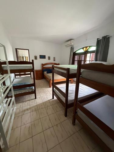 a room with three bunk beds in a room at Sobrado 3 Praias in Ubatuba