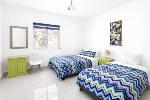 a bedroom with two beds and a desk and a chair at Mansion Cumbres Vista Panoramica Monterrey in Monterrey