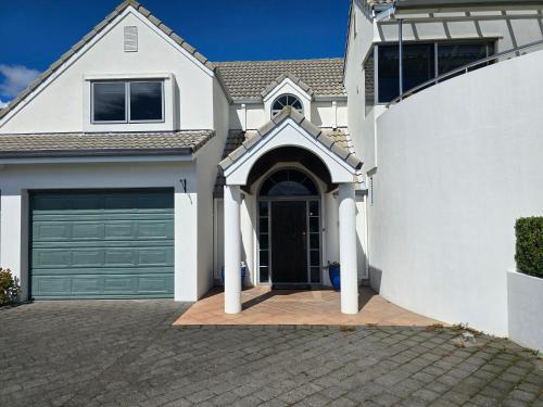 a white house with a garage at Island View in Tauranga