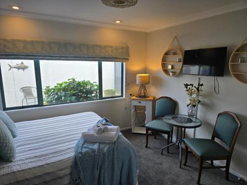 a bedroom with a bed and a window and a table at Island View in Tauranga