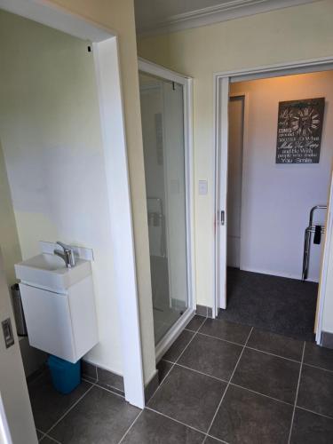 a bathroom with a toilet and a sink and a mirror at Island View in Tauranga