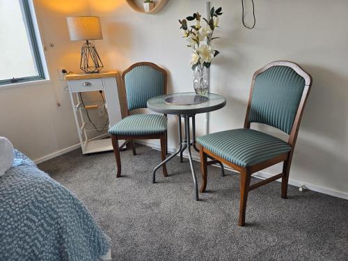 a room with two chairs and a table and a table and chairs at Island View in Tauranga