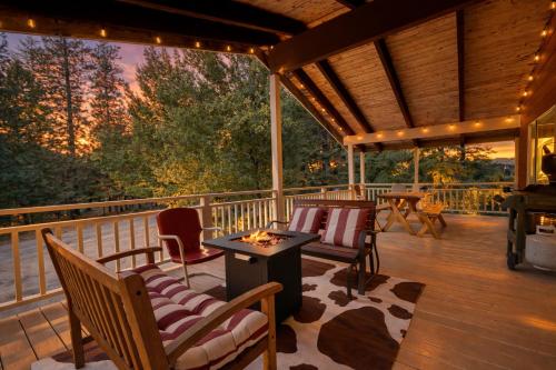 a porch with chairs and a table on a deck at Maple Leaf Lodge by NW Comfy Cabins in Leavenworth